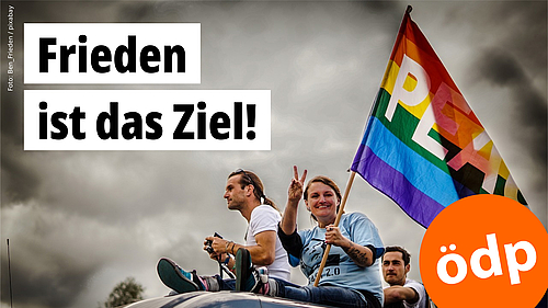 Drei Personen mit einer Friedensfahne sitzen auf einem Autodach und machen mit den Händen das Friedenssymbol