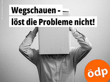 Das PFAS-Problem wird sich nicht von alleine lösen. Das schwarz-weiß-Foto zeigt einen Mann, der sich einen großen Karton über den Kopf gezogen hat und ihn mit beiden Händen festhält