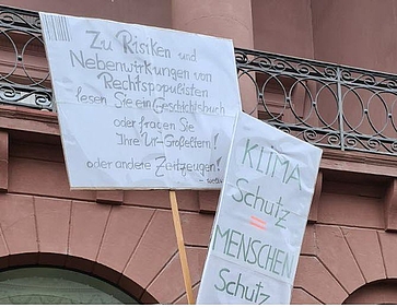 Auf Plakaten werden Klimaschutz und Schutz der Demokratie gefordert. Auf Plakaten werden Klimaschutz und Schutz der Demokratie gefordert.